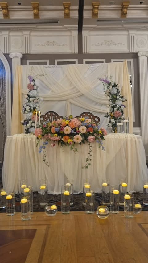 Candlelit sweetheart table with drapery and florals