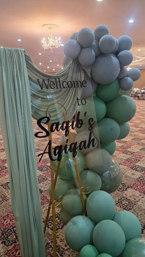 Acrylic signage with drapery and balloon column at an entrance